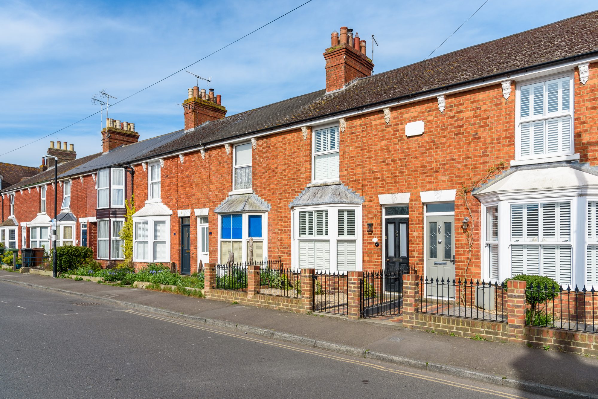 Red-brick terraced houses with bay windows in Cheshire, typical of homes surveyed by Greenarcha